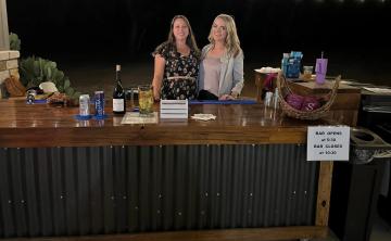 The Moss Ranch TABC Bartenders, Abby and Caitlin serving drinks to wedding guests.